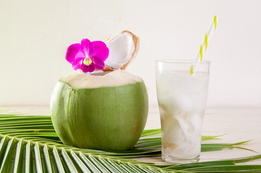 Young Coconut Water in a shell and then in a glass with a straw.