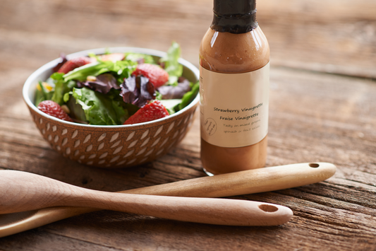 Salad with a bottle of dressing with a wooden spatula.